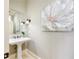 Stylish powder room featuring a pedestal sink, decorative mirror, and elegant sconces at 2760 Sugarloaf Club Dr, Duluth, GA 30097
