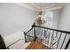Elegant staircase featuring decorative wrought iron railing, neutral carpet, and a statement chandelier at 2760 Sugarloaf Club Dr, Duluth, GA 30097
