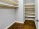 Walk-in closet with custom shelving and hardwood floors, maximizing storage space at 2760 Sugarloaf Club Dr, Duluth, GA 30097