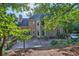 The backyard featuring a wooden deck, mature trees, and well-maintained landscaping at 3875 Sweetwater Dr, Cumming, GA 30041