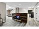 Finished basement with hardwood floors, modern bar, and neutral gray walls and lighting at 3875 Sweetwater Dr, Cumming, GA 30041