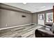 Finished basement with gray walls, hard flooring, a leather couch and a door to the backyard at 3875 Sweetwater Dr, Cumming, GA 30041