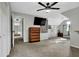 Carpeted bedroom includes ceiling fan, mounted TV and a view to the hallway at 3875 Sweetwater Dr, Cumming, GA 30041