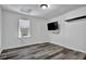 Bright bedroom with wood-look flooring, a single window, and a wall-mounted television at 3875 Sweetwater Dr, Cumming, GA 30041