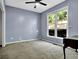 Neutral-toned bedroom with ceiling fan, carpeted floors, and a window view at 3875 Sweetwater Dr, Cumming, GA 30041