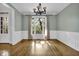Light and airy dining room with beautiful hardwood floors, elegant chandelier, and modern paneling at 3875 Sweetwater Dr, Cumming, GA 30041