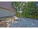 Attached two-car garage with a concrete driveway surrounded by trees at 3875 Sweetwater Dr, Cumming, GA 30041