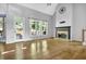 Inviting living room with fireplace, hardwood floors, large windows, and access to back deck at 3875 Sweetwater Dr, Cumming, GA 30041