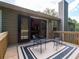 View of the home's back deck with a table and chairs, with black framed double doors leading to the interior at 803 Plantation Ridge Overlook, Woodstock, GA 30188