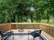 Outdoor deck with chairs, a table, and serene view of the backyard and woods at 803 Plantation Ridge Overlook, Woodstock, GA 30188