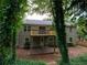 Home's back exterior featuring a walk-out basement, spacious deck, and a large backyard with mature trees at 803 Plantation Ridge Overlook, Woodstock, GA 30188