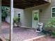 Backyard area below the deck has a small patio area, a door to the lower level, and mature landscaping at 803 Plantation Ridge Overlook, Woodstock, GA 30188