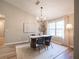 Well-lit dining room featuring a modern chandelier, a natural rug, and a large picture window at 803 Plantation Ridge Overlook, Woodstock, GA 30188