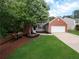 Charming single-Gathering home with well-manicured lawn, mature trees, brick accents, and an attached garage at 803 Plantation Ridge Overlook, Woodstock, GA 30188