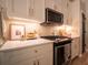 Bright kitchen features modern appliances, white cabinets, quartz counters, and updated hardware at 803 Plantation Ridge Overlook, Woodstock, GA 30188