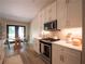 Bright kitchen features stainless steel appliances, white cabinets, and access to the breakfast nook at 803 Plantation Ridge Overlook, Woodstock, GA 30188