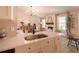 Open concept kitchen and living room with white cabinets, quartz counters and stainless steel sink at 803 Plantation Ridge Overlook, Woodstock, GA 30188