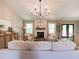 Cozy living room with a white sofa, stone fireplace, and lots of natural light at 803 Plantation Ridge Overlook, Woodstock, GA 30188