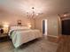 Spacious bedroom featuring wood floors, a modern chandelier, and stylish decor at 803 Plantation Ridge Overlook, Woodstock, GA 30188