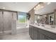 Bright bathroom featuring a double vanity, bathtub, and a separate glass shower at 13574 Se Whitman Ln, Covington, GA 30014