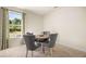 Cozy dining room with a round table, gray chairs, and a large window overlooking the backyard at 13574 Se Whitman Ln, Covington, GA 30014