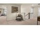 Hallway with an accent chair, lamp, art on the walls, and view into the adjacent living area at 13574 Se Whitman Ln, Covington, GA 30014