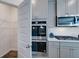 Modern kitchen featuring a double oven and gas cooktop, next to a pantry at 13574 Se Whitman Ln, Covington, GA 30014