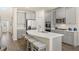 Stylish kitchen featuring gray cabinets, stainless steel appliances, and an island with seating at 13574 Se Whitman Ln, Covington, GA 30014
