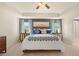 Main bedroom with ceiling fan, tray ceiling, neutral decor and ensuite access at 13574 Se Whitman Ln, Covington, GA 30014
