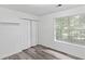 Bedroom features natural light from the window, closet, and modern flooring at 1901 Cherwell Dr, Riverdale, GA 30296