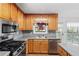 Well-lit kitchen showcasing modern stainless appliances and charming wood cabinetry at 1901 Cherwell Dr, Riverdale, GA 30296