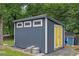 Exterior shot of a recently-built storage shed with grey siding and yellow doors at 41 Spring Nw Ln, Atlanta, GA 30314