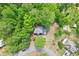 An aerial shot shows a home nestled among lush greenery, showcasing its serene and private setting at 6230 Lillie Ln, Cumming, GA 30040