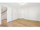 Bedroom featuring hardwood floors, neutral walls, and access to a staircase at 6230 Lillie Ln, Cumming, GA 30040