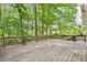 Large wooden deck surrounded by lush trees, offering a serene outdoor space at 6230 Lillie Ln, Cumming, GA 30040