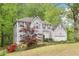 Charming two-story home with light siding, a well-manicured lawn, and mature trees at 6230 Lillie Ln, Cumming, GA 30040