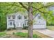 Traditional two-story home with a well-kept lawn, mature trees, and an attached two-car garage at 6230 Lillie Ln, Cumming, GA 30040