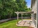 A covered back patio with a ceiling fan overlooks a grassy yard and is perfect for outdoor entertaining at 144 Nocatee Trl, Woodstock, GA 30188