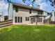 The backyard features a covered patio, green lawn and mature trees, offering a private outdoor space at 144 Nocatee Trl, Woodstock, GA 30188