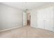 Neutral bedroom with double closets, neutral paint, and an open door to the next room at 144 Nocatee Trl, Woodstock, GA 30188