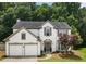 Charming two-story home boasts a two-car garage and manicured front yard with mature trees at 144 Nocatee Trl, Woodstock, GA 30188