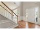Bright foyer with hardwood floors, staircase, and ample natural light creates a welcoming entrance at 144 Nocatee Trl, Woodstock, GA 30188