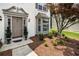 Elegant front entrance features a classic door, beautiful landscaping, and a bay window at 144 Nocatee Trl, Woodstock, GA 30188