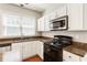 Functional kitchen featuring white cabinets, stainless steel appliances, and granite countertops at 144 Nocatee Trl, Woodstock, GA 30188