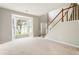 Bright living room features a large bay window and staircase, creating a welcoming atmosphere at 144 Nocatee Trl, Woodstock, GA 30188
