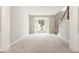 Open-concept living room with neutral colors, large bay window, and staircase access at 144 Nocatee Trl, Woodstock, GA 30188