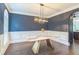 Elegant dining room featuring modern lighting, hardwood floors, and stylish wainscoting details at 2260 Cobble Creek Ln, Grayson, GA 30017