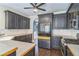Well-lit kitchen featuring dark cabinets, stainless steel appliances, granite countertops, and hardwood floors at 2260 Cobble Creek Ln, Grayson, GA 30017