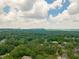 Scenic aerial view of a community with lush trees and distant buildings under a bright sky at 4096 Vinings Mill Se Trl, Smyrna, GA 30080