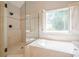 Bathroom with walk-in shower, soaking tub, and large window with plantation shutters at 4096 Vinings Mill Se Trl, Smyrna, GA 30080